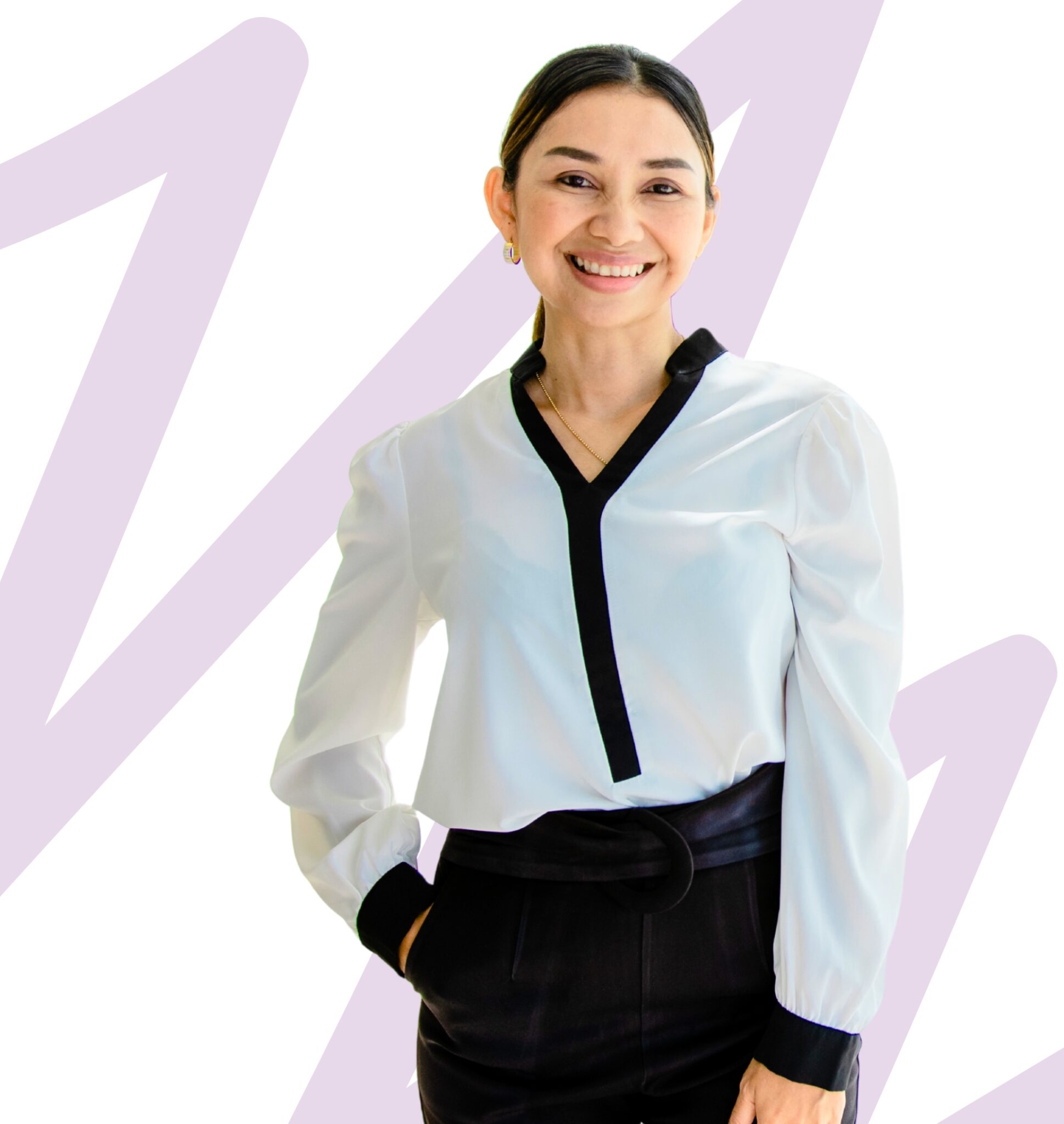 A confident, smiling woman wearing a white blouse with black trim, hands in pocket, standing against a modern abstract background.